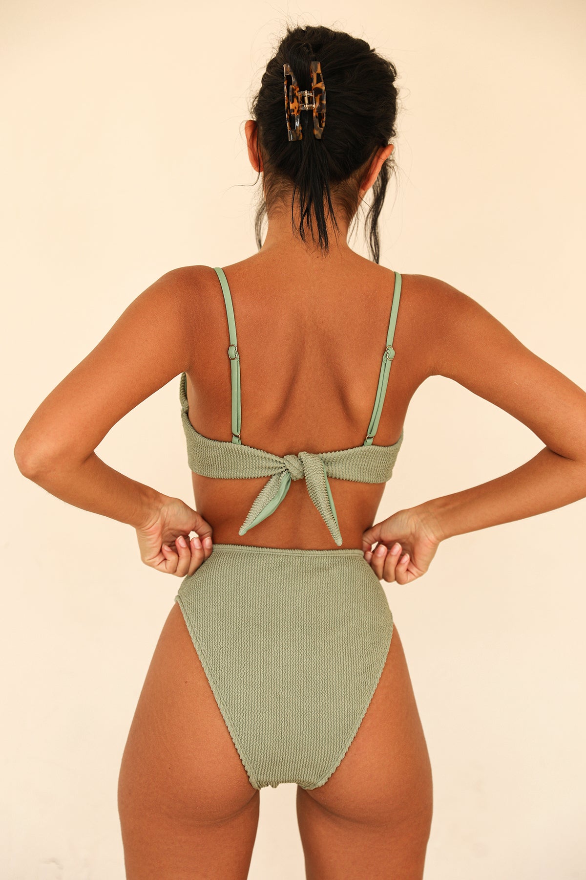UNIKONCEPT Lifestyle Boutique and Lounge; Dippin Daisys Seashore bottom in Sage featured on a model. High-waisted sage green bikini bottoms