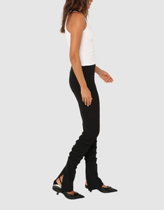 Photo of model wearing Dominique Gathered pants in black with back slit detail available at UniKoncept in Waterloo side view