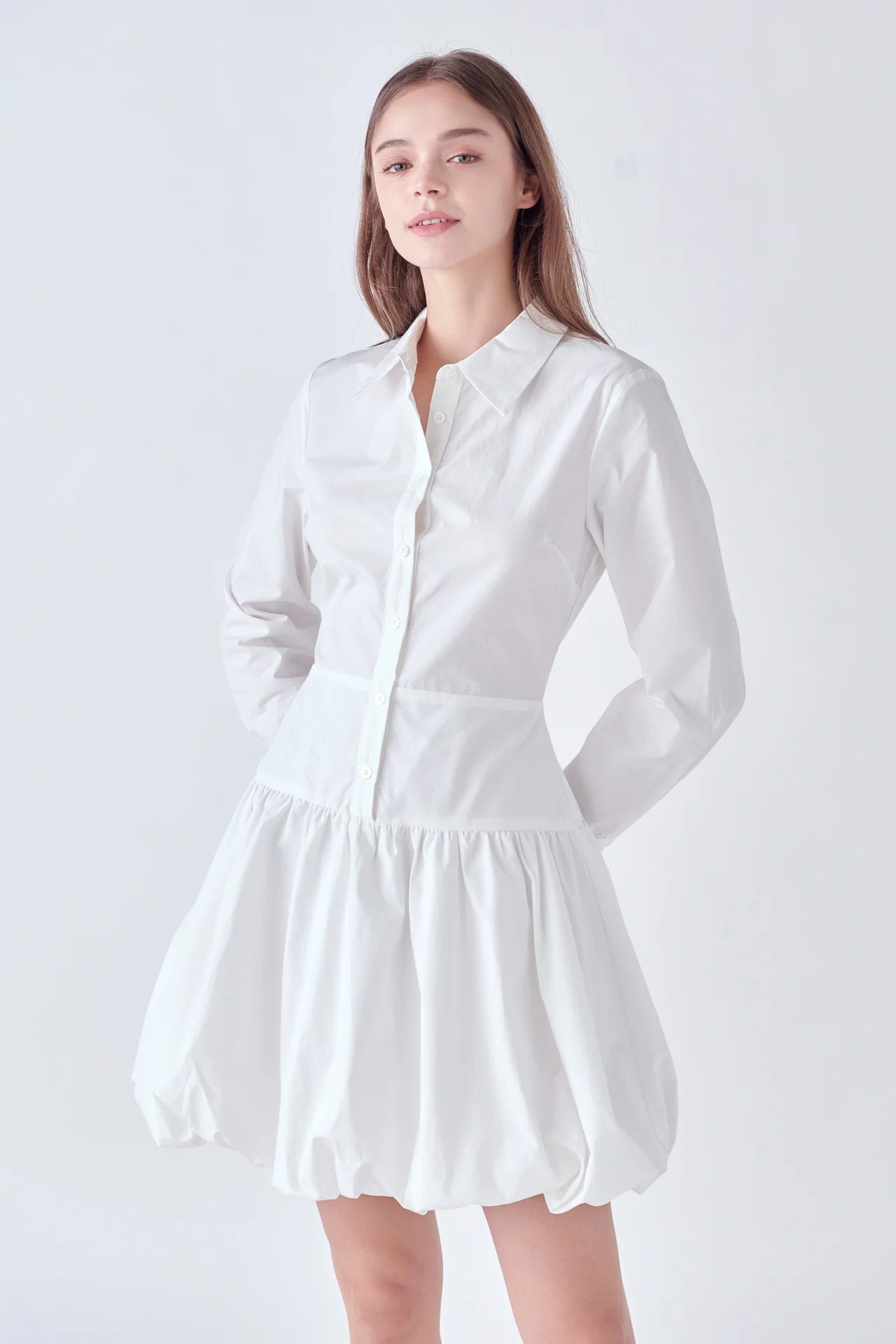 Photo of model wearing Poppy Poplin Button Up Dress in White With bubble skirt, button detailing, and collar available at UniKoncept in Waterloo front view