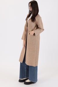 Photo of model wearing Judith Long Knit Coat in a camel colour with a button detail available at UniKoncept in Waterloo side view