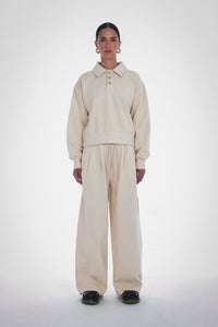 Photo of Model wearing Wen Pleated Pants in an oatmeal colour with pleated wide leg detailing and drawstring from Paper the Label available at UniKoncept in Waterloo - Front View Featuring Matching Klee Polo Sweatshirt