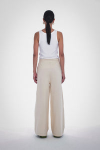Photo of Model wearing Wen Pleated Pants in an oatmeal colour with pleated wide leg detailing and drawstring from Paper the Label available at UniKoncept in Waterloo - Back View