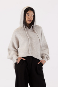 Photo of model wearing charlie eco hoodie in an oatmeal colour available at UniKoncept in Waterloo front view with hood up