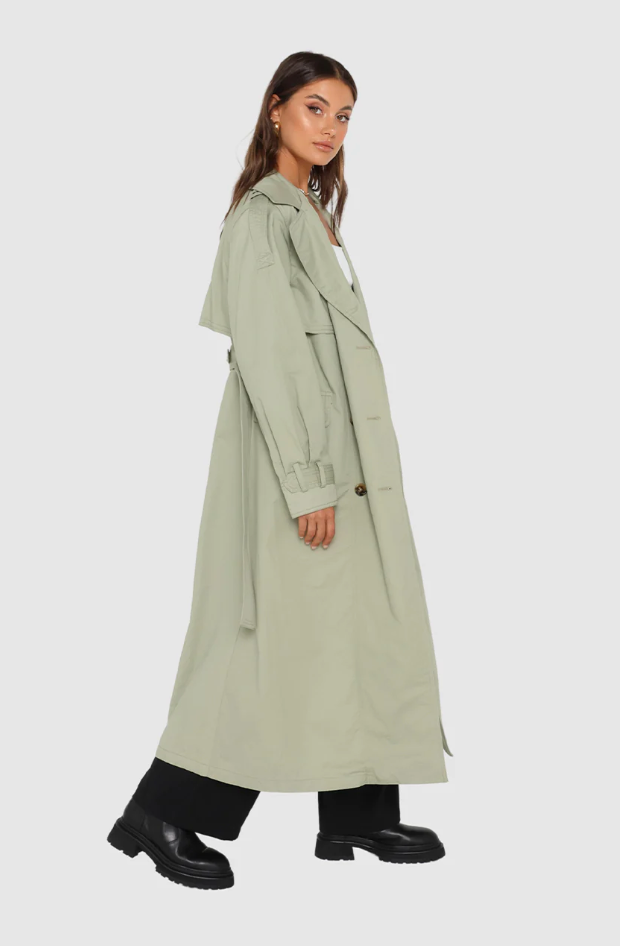 Photo of model wearing Diana Trench Coat in a sage green colour available at UniKoncept in Waterloo side view