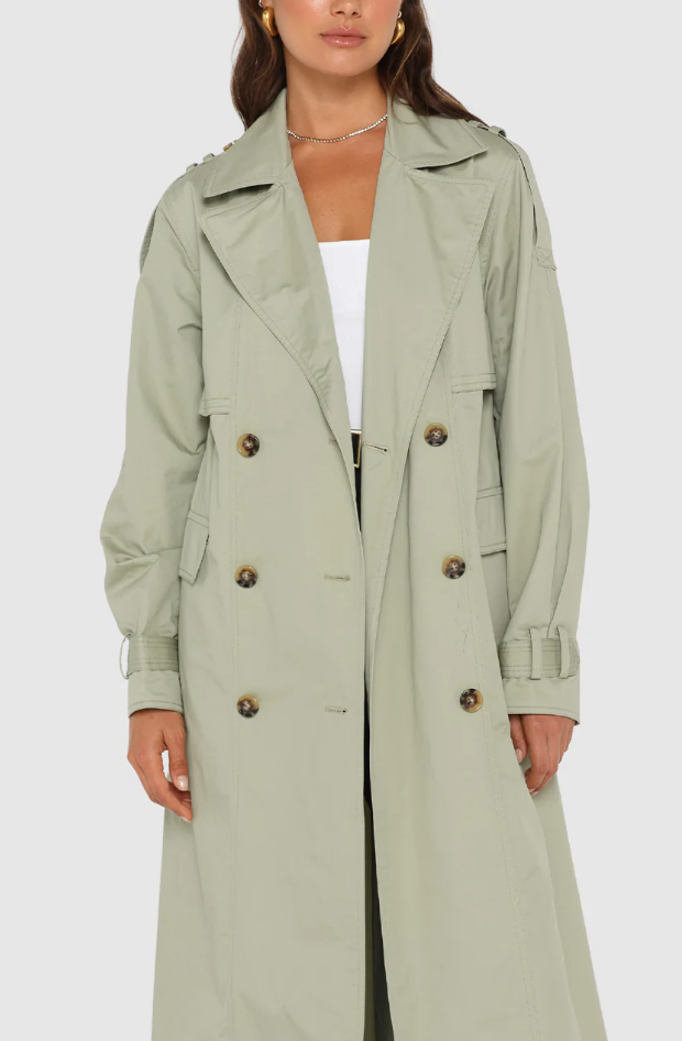 Photo of model wearing Diana Trench Coat in a sage green colour available at UniKoncept in Waterloo close up of front with button details
