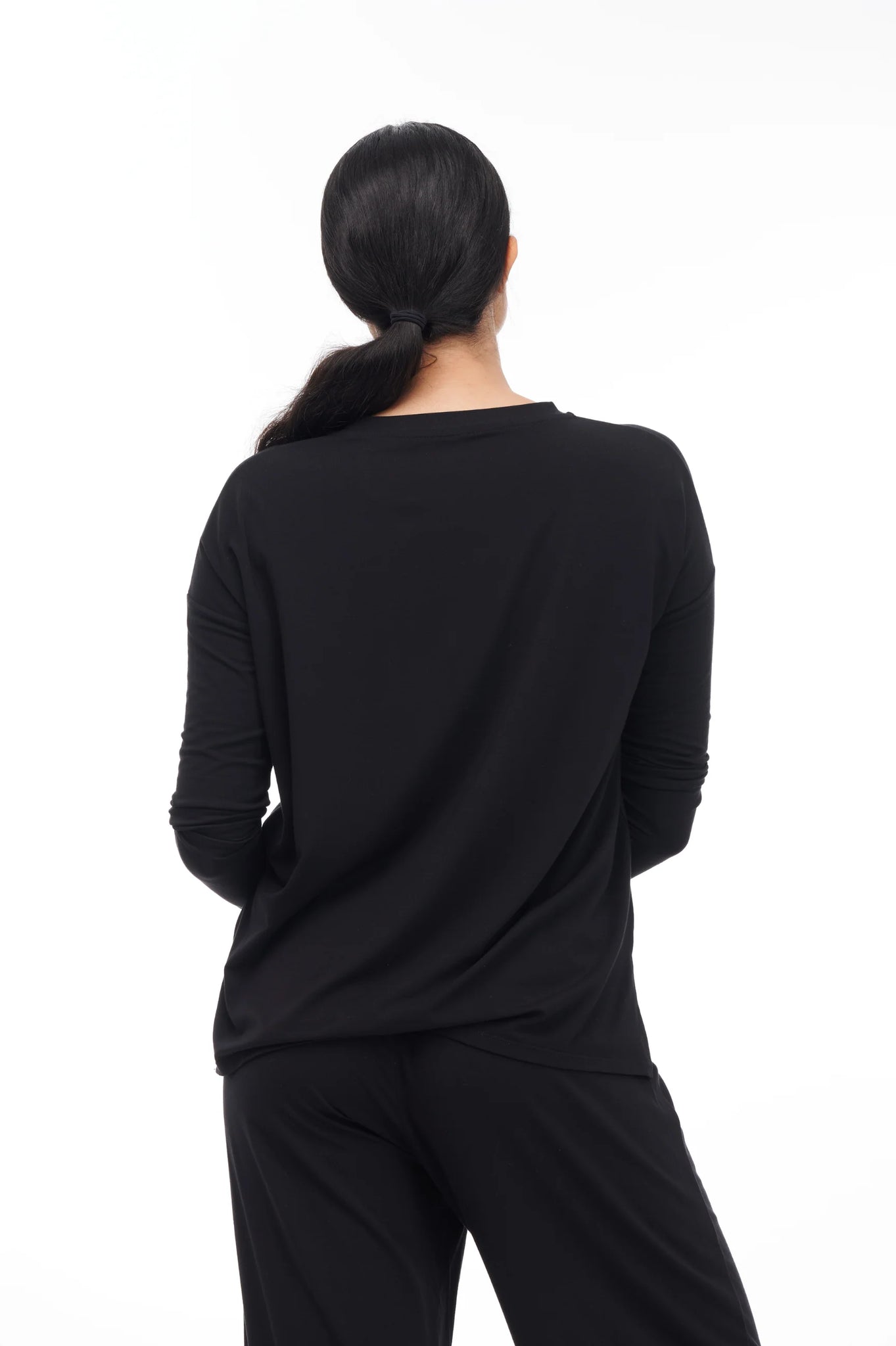 Photo of model wearing Everette Lounge Set in the colour black from paper label available at UniKoncept in Waterloo black coloured long sleeve top and pants back view photo of top
