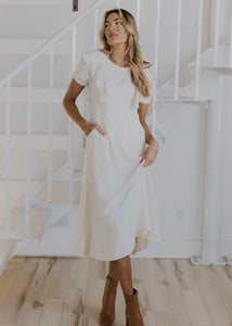 Model is wearing Lovella Ruffle Nursing Dress in Neutral with ruffle details from Roolee available at UniKoncept in Waterloo