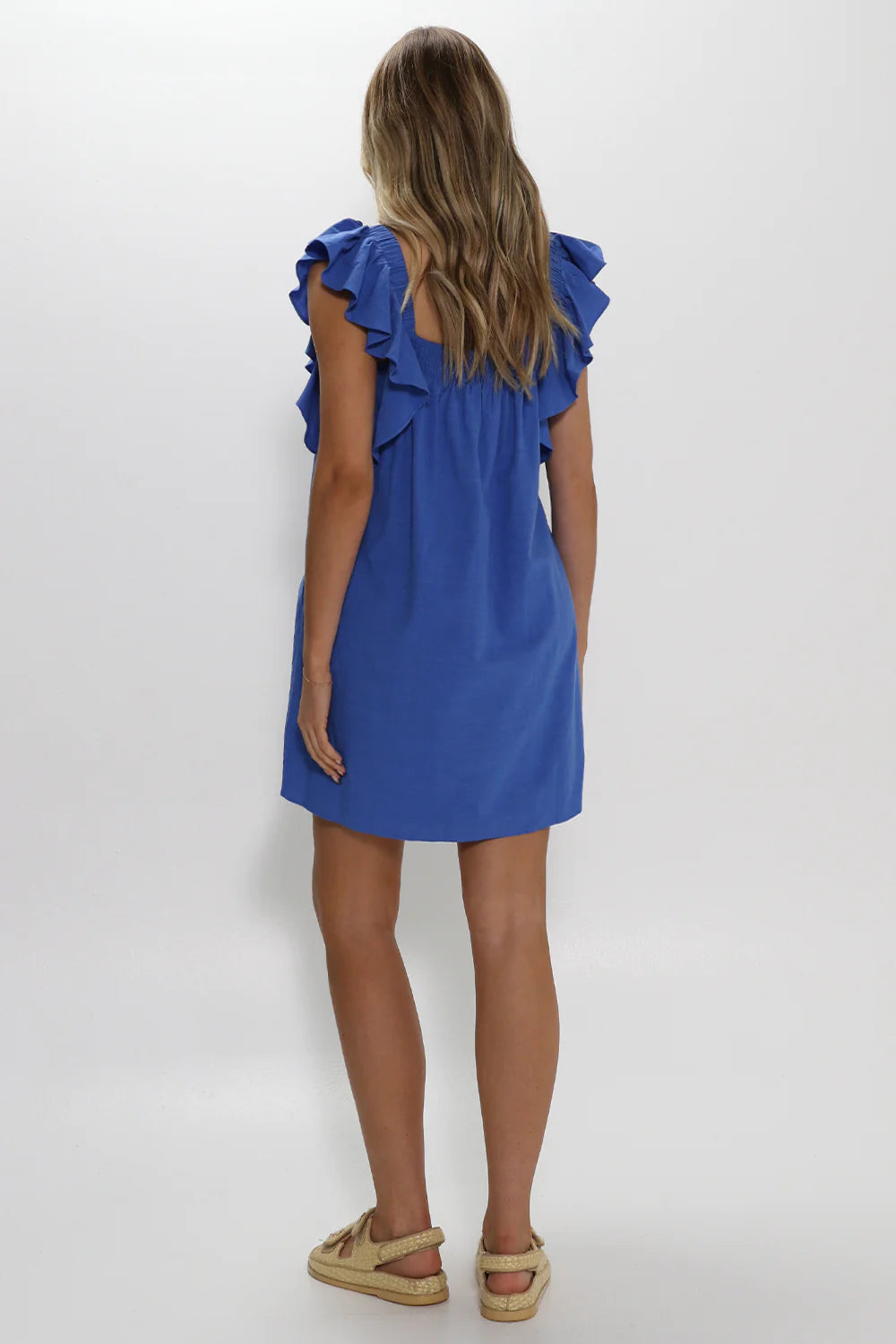 Model is wearing Essie dress from Lost in Lunar in blue with shoulder ruffle details available at UniKoncept in Waterloo