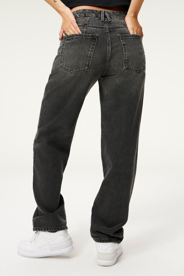 UNIKONCEPT Lifestyle Boutique and Lounge ; Model wearing Good American Good 90s Jeans in Black - a loose-fitting mid-rise baggy black jean