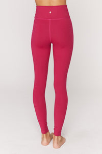 UNIKONCEPT Lifestyle boutique: Image shows the essential HW leggings by Spiritual Gangster. These highwaisted leggings come in berry red with the brand name printed down the left leg in pink capital lettering.