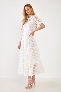 UNIKONCEPT Lifestyle Boutique and Lounge; Model wearing Vera Organza Collared Dress by English Factory. A white grid organza midi dress with puffed sleeves, button-down bodice and collar.