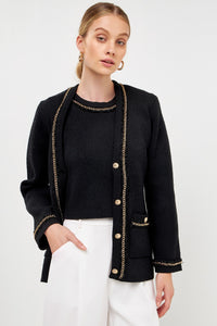 UNIKONCEPT Lifestyle Boutique and Lounge; Model wearing Gold Chain Cardi in Black by English Factory. A knit cardigan with gold buttons and chain details on the cuffs, pockets, and neckline