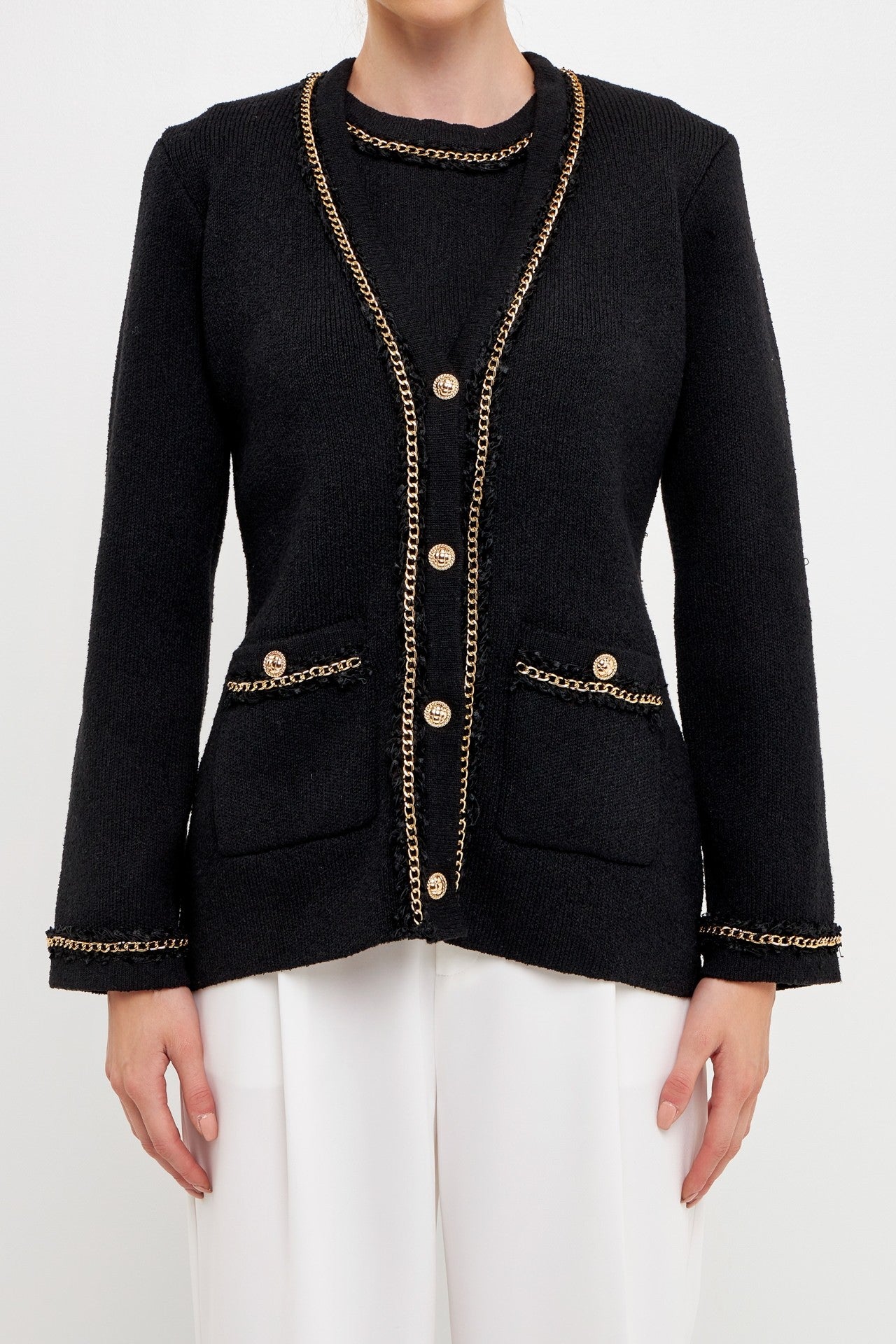 UNIKONCEPT Lifestyle Boutique and Lounge; Model wearing Gold Chain Cardi in Black by English Factory. A knit cardigan with gold buttons and chain details on the cuffs, pockets, and neckline