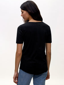 Model wearing black, v-neck, KOTN t-shirt. View of Models back.