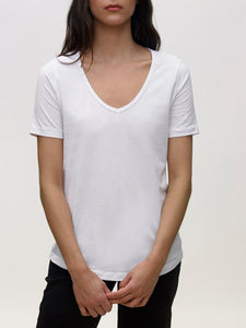 Model wearing white, v neck, KOTN t-shirt. 