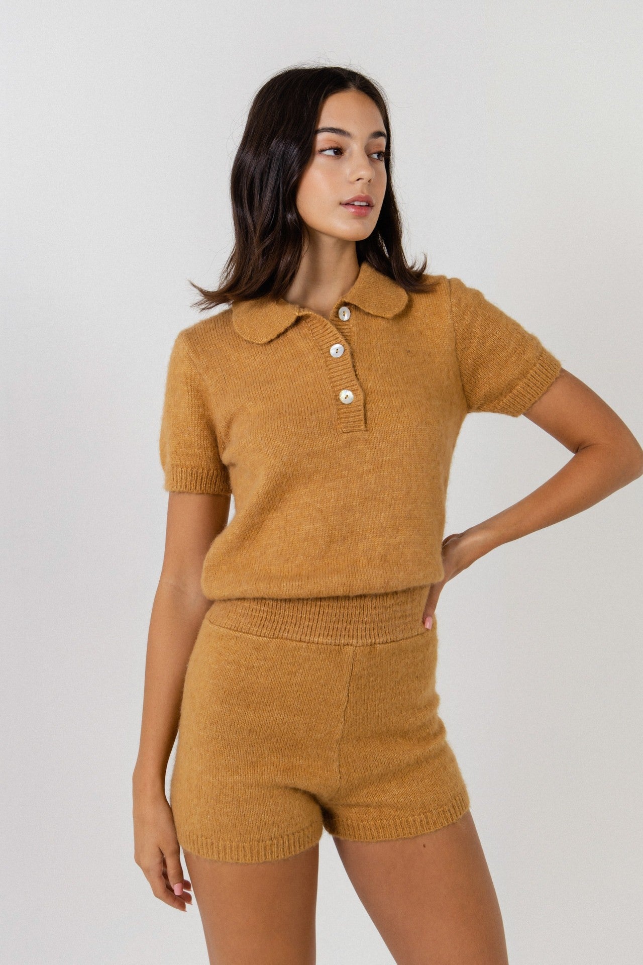UNIKONCEPT Lifestyle Boutique and Lounge; Model wearing Cozy Chalet Romper in gold by English Factory - a knit romper with short sleeves and polo button collar