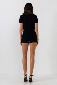 UNIKONCEPT Lifestyle Boutique and Lounge; Model wearing Cozy Chalet Romper in black by English Factory - a knit romper with short sleeves and polo button collar